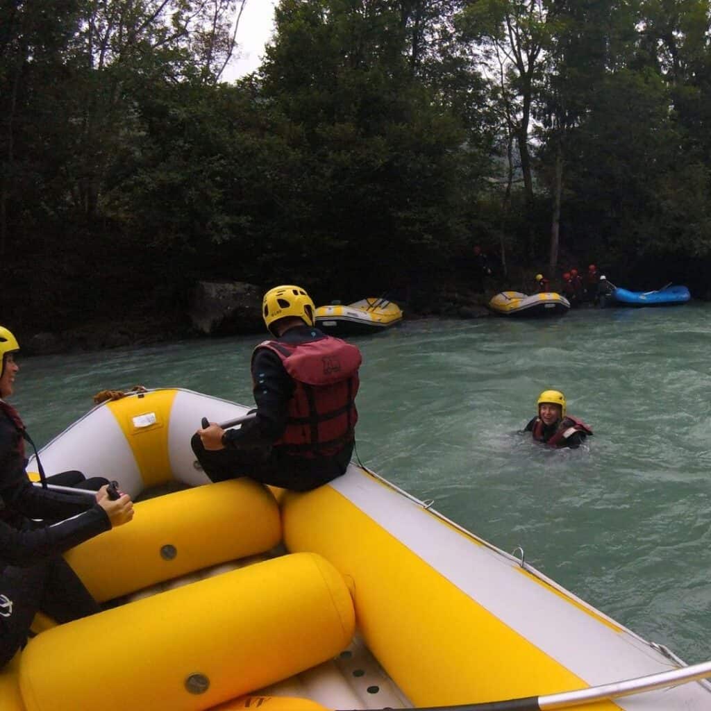 Participant swimming in the Isère River during a guided white water rafting adventure with AN Rafting near La Plagne.