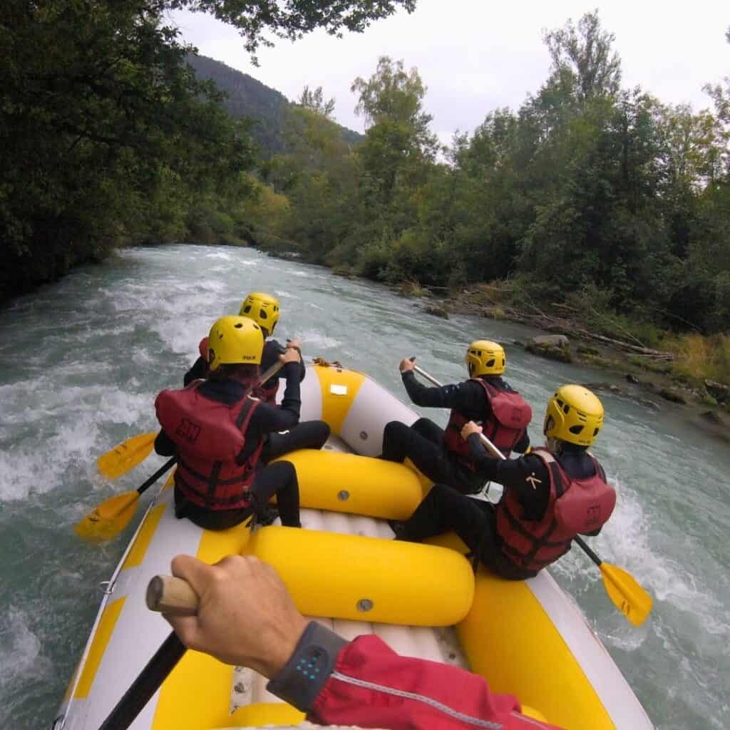 Raft paddling through exciting rapids on the Isère River during a white water rafting trip near La Plagne with AN Rafting.
