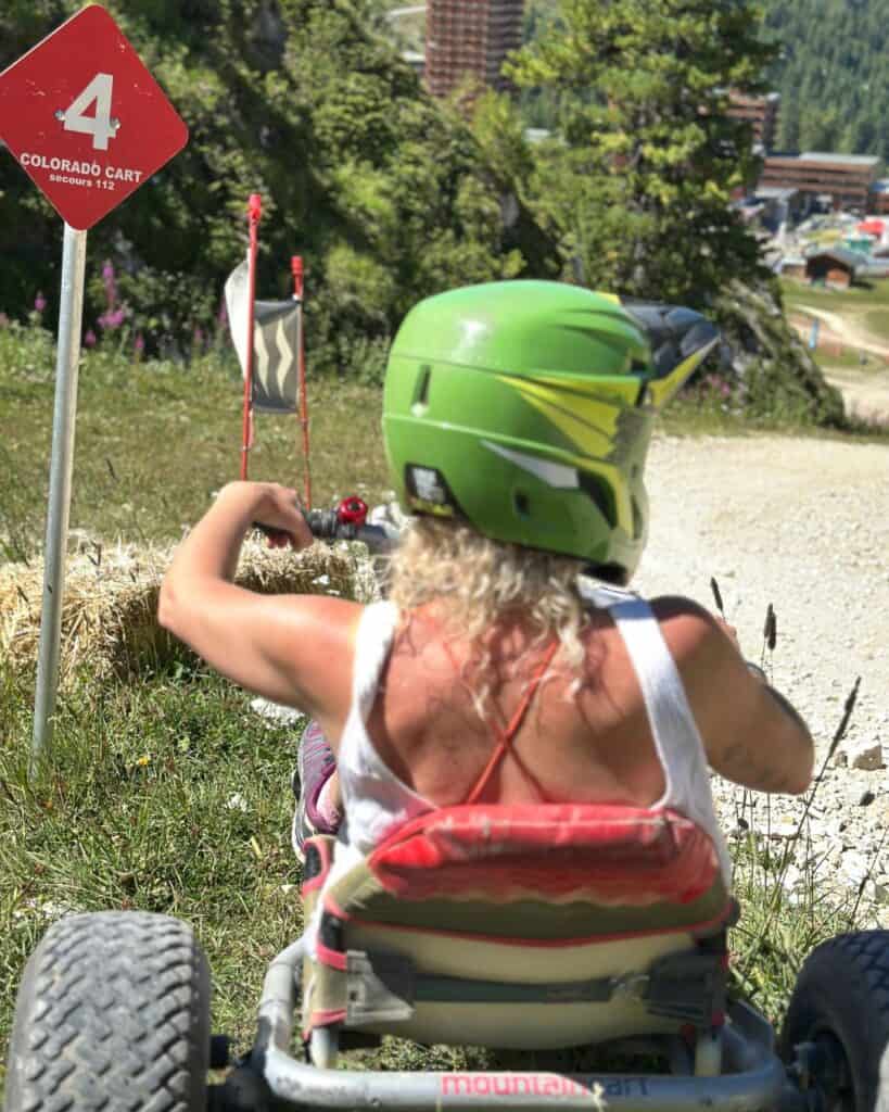 Mountain cart rider beside a Colorado Cart trail marker on the mountain above Montalbert in La Plagne.