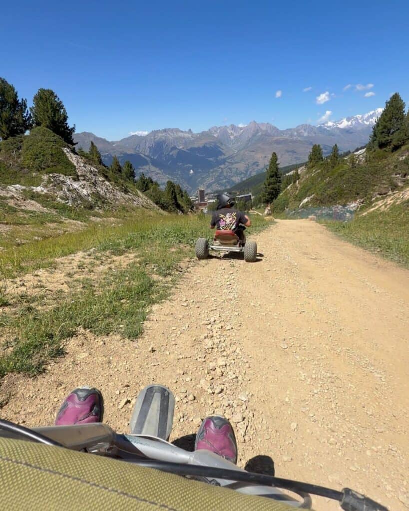 POV mountain carting on the red track in Plagne Centre, following another rider through the summer mountain landscape.