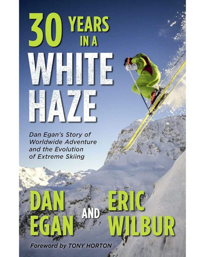 Book cover for 30 Years in a White Haze by Dan Egan and Eric Wilbur, featuring an extreme skier in a neon green suit launching off a steep slope with dramatic alpine peaks in the background. The book documents worldwide skiing adventures and the evolution of extreme skiing.