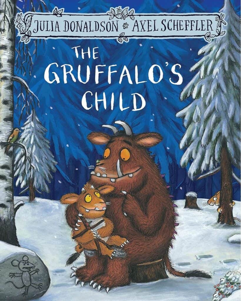 The Gruffalo’s Child by Julia Donaldson and Axel Scheffler: Illustrated book cover featuring a large Gruffalo creature sitting in a snowy forest, holding a smaller Gruffalo child. A mouse carving is seen on a rock, and woodland animals peek from behind trees.