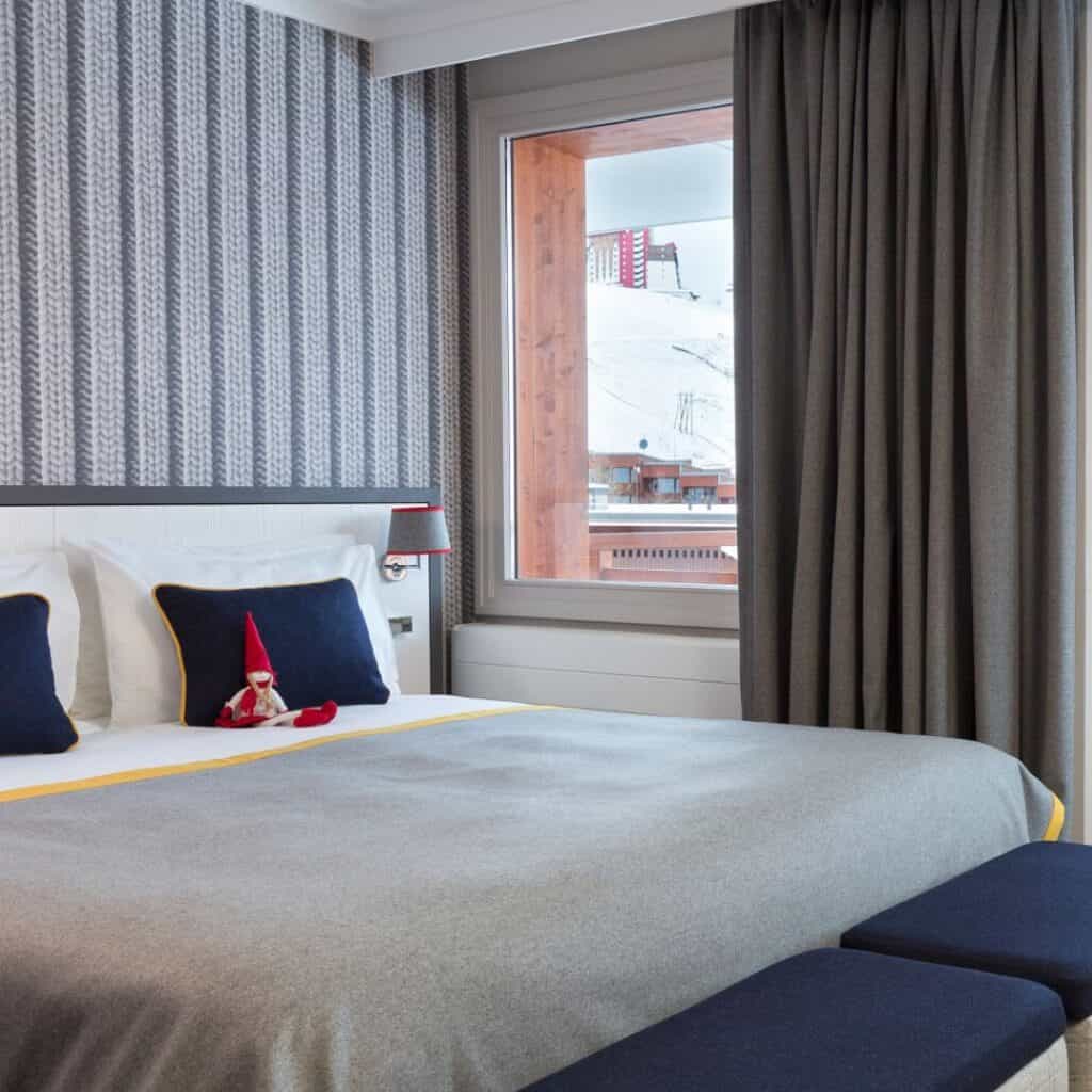 Modern double room with alpine-themed decor and a scenic view of the slopes, showcasing the best accommodation Plagne Centre for a comfortable and stylish stay.
