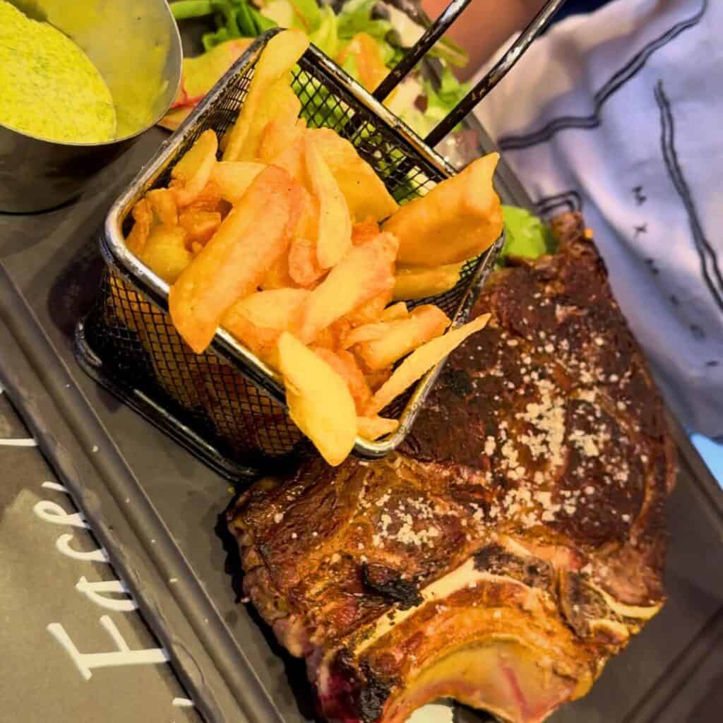 A hearty serving of steak and golden fries at a mountain restaurant, representing the delicious local dining options around the best accommodation Belle Plagne.