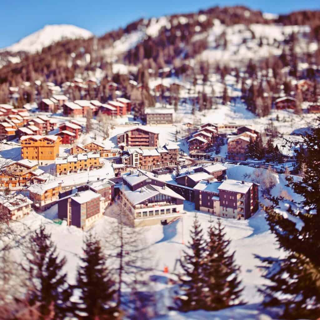 A tilt-shift style photo of La Plagne village highlighting charming chalets and lodges, reinforcing the area's reputation for the best ski accommodation in the Alps.