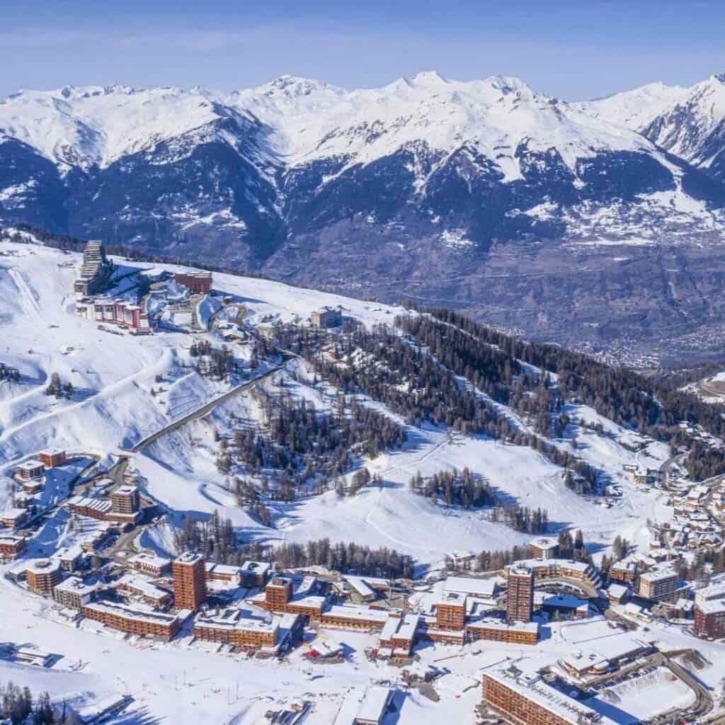 Panoramic aerial photo of Plagne Centre surrounded by snowy mountains, showcasing the range of the best accommodation Plagne Centre in the heart of the resort.