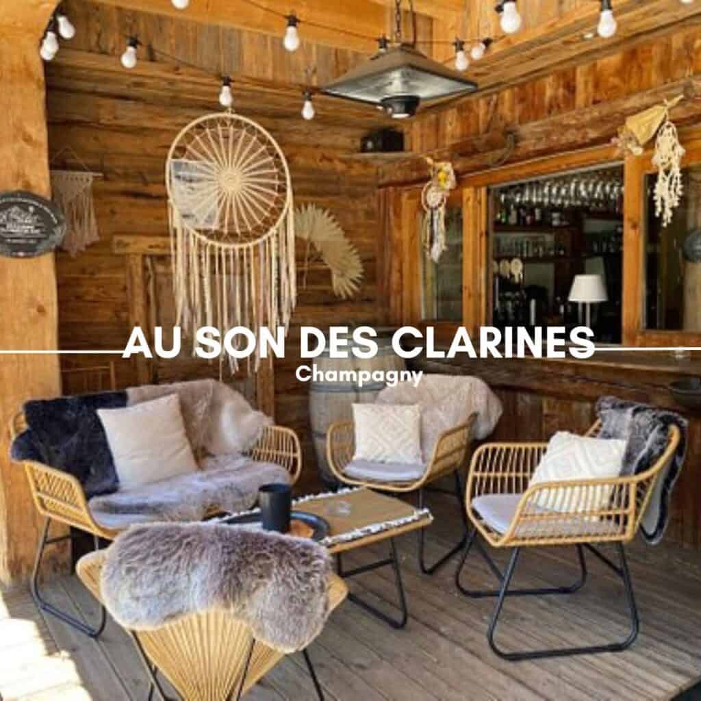 AU SON DES CLARINES, Champagny – A charming wooden restaurant with a rustic interior, decorated with vintage ski posters, a chalkboard menu, and shelves of drinks. The tables are set for a casual dining experience.