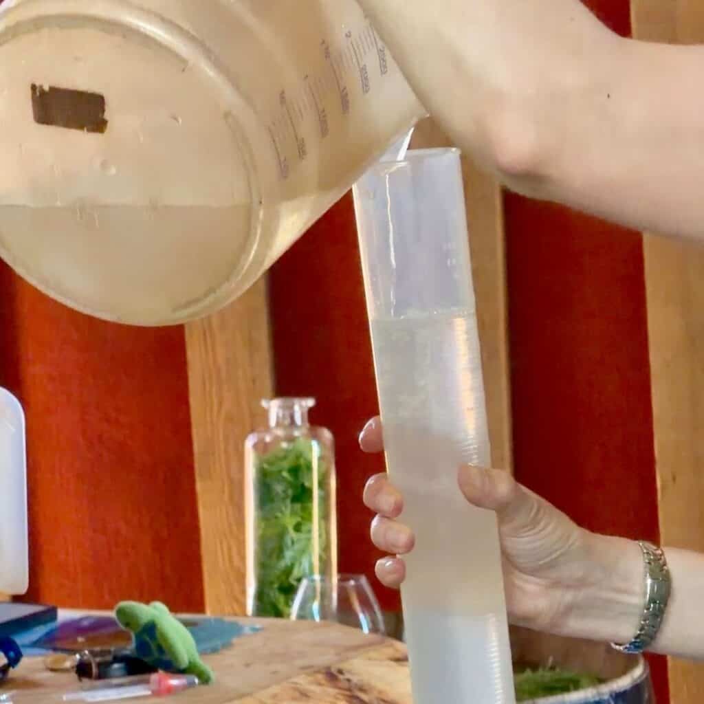 Mixing alcohol and water during the process of making a traditional Alpine liqueur.