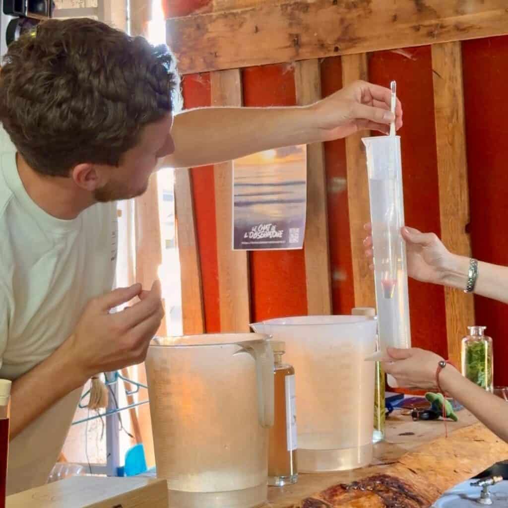 Testing the alcohol content of a liqueur mixture during a distillery workshop in Granier.