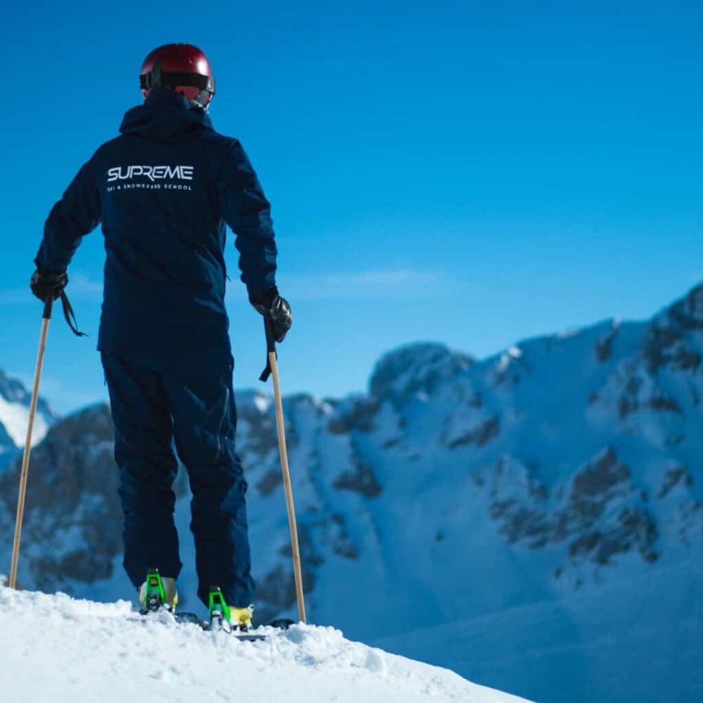 Supreme Ski School instructor skiing in La Plagne with snowy mountain views in the background